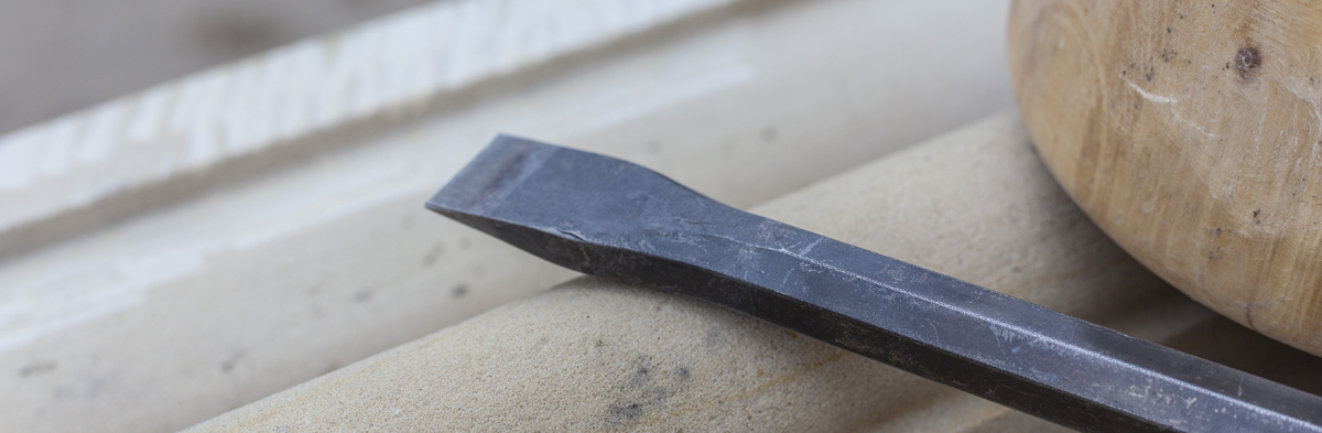 Hammer und Meißel als traditionelle Werkzeuge des Steinmetzhandwerks